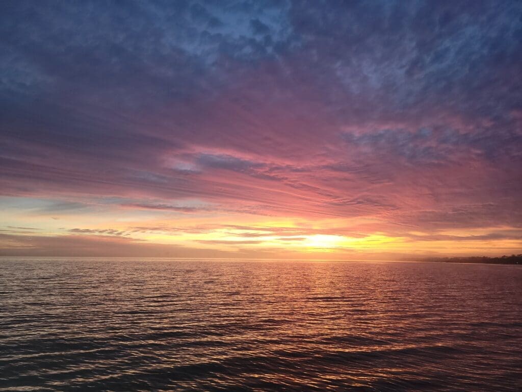 A breathtaking and romantic evening sunset view from a private six-passenger pontoon tour cruising the waters of the Emerald Coast.