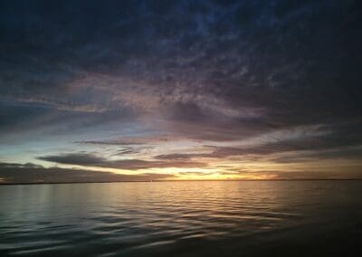 The sun casting a golden glow across the bay, perfect for a relaxing evening captained boat tour.