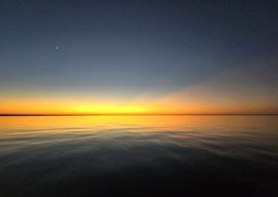 Pink and purple twilight skies over the bay during an evening dolphin and sunset cruise in Pensacola.