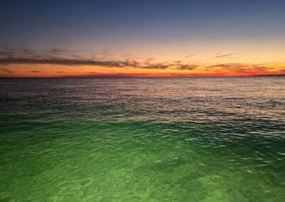 Calm evening waters reflecting a bright sunset on a VIP 6-passenger captained boat charter.