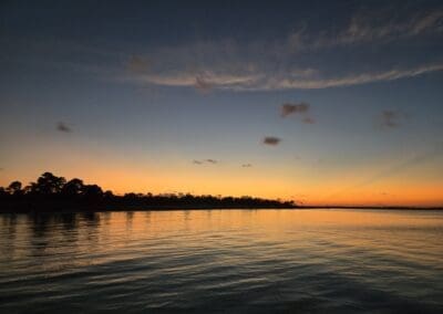 Golden hour sunlight reflecting off the calm waters of the Santa Rosa Sound from the deck of a luxury tritoon.